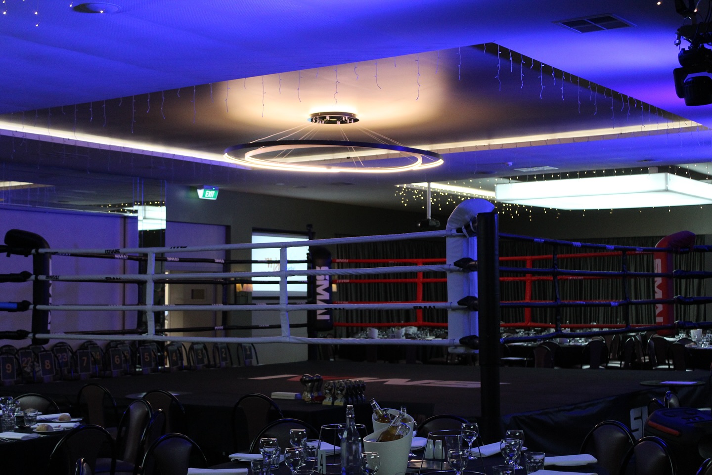 Boxing ring set up in the Club Da Vinci ballroom under blue and purple lighting